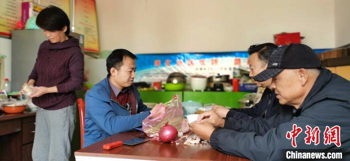 圖為扶貧路上“臨時(shí)一家人”準(zhǔn)備午餐?！∥航ㄜ?攝