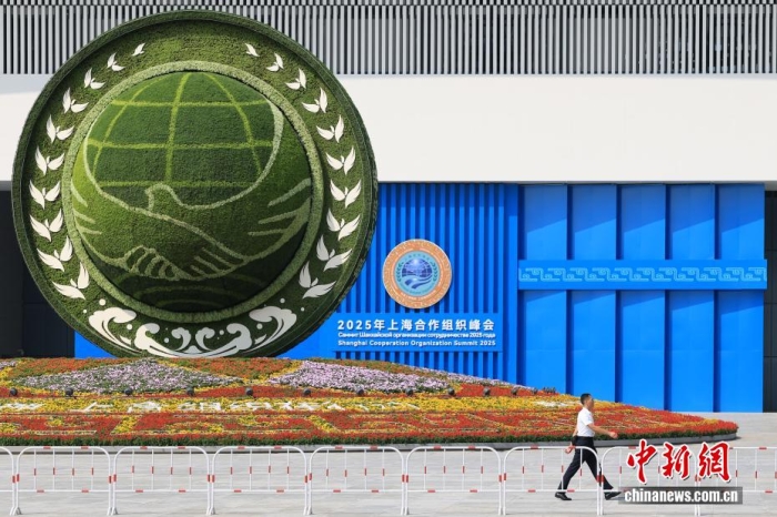 8月31日，天津，一名工作人員從2025年上海合作組織峰會主會場外的景觀花壇旁經(jīng)過。當日，2025年上海合作組織峰會在天津舉行。<a target='_blank' href='/'><p  align=