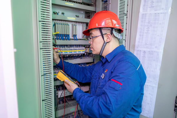 呂曉勇在保護(hù)盤柜前檢查二次回路接線情況。受訪者供圖