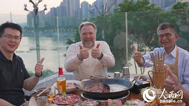 康寧顯示科技事業(yè)部全球拓建項目總監(jiān)軻寶華（中）和同事在重慶南濱路吃火鍋。人民網(wǎng)記者 蘇纓翔攝