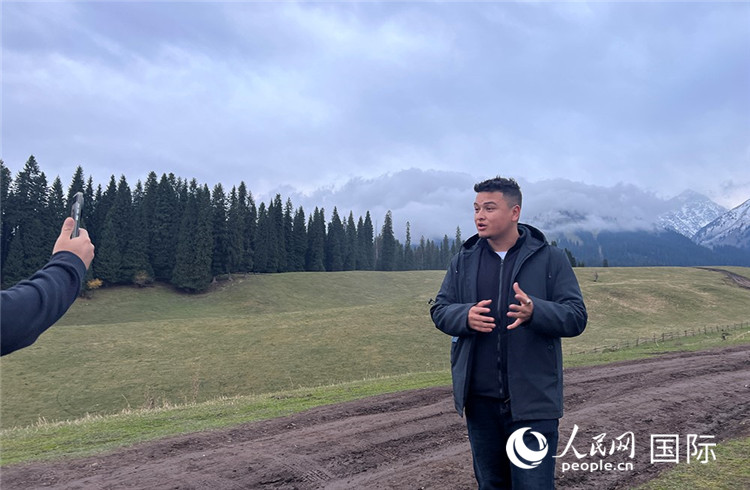 在庫爾德寧，吾買爾江被雪山美景震撼，即興錄制了短視頻作品。人民網(wǎng)記者曾書柔攝