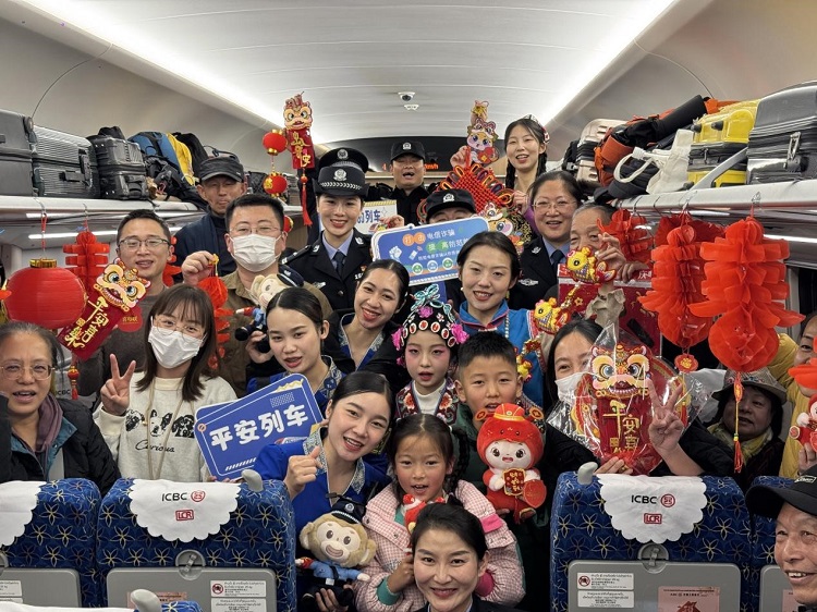 春節(jié)期間，在中老鐵路磨萬（磨丁—萬象）段，鐵路客運員工與乘客合影留念。李加勇攝