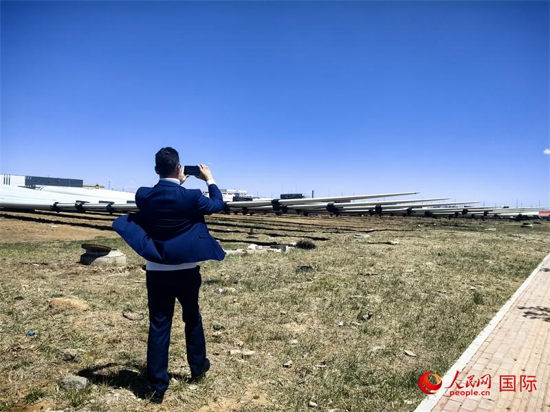 外媒記者拍攝廠房外的風力渦輪發(fā)電機的巨型漿葉。人民網 楊春燕攝