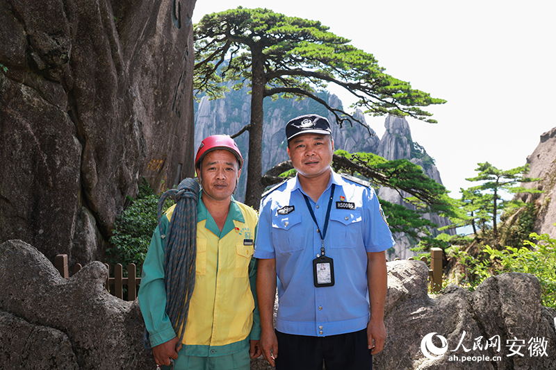 全國(guó)道德模范李培生（左）和胡曉春在迎客松前合影。人民網(wǎng)記者 張俊攝