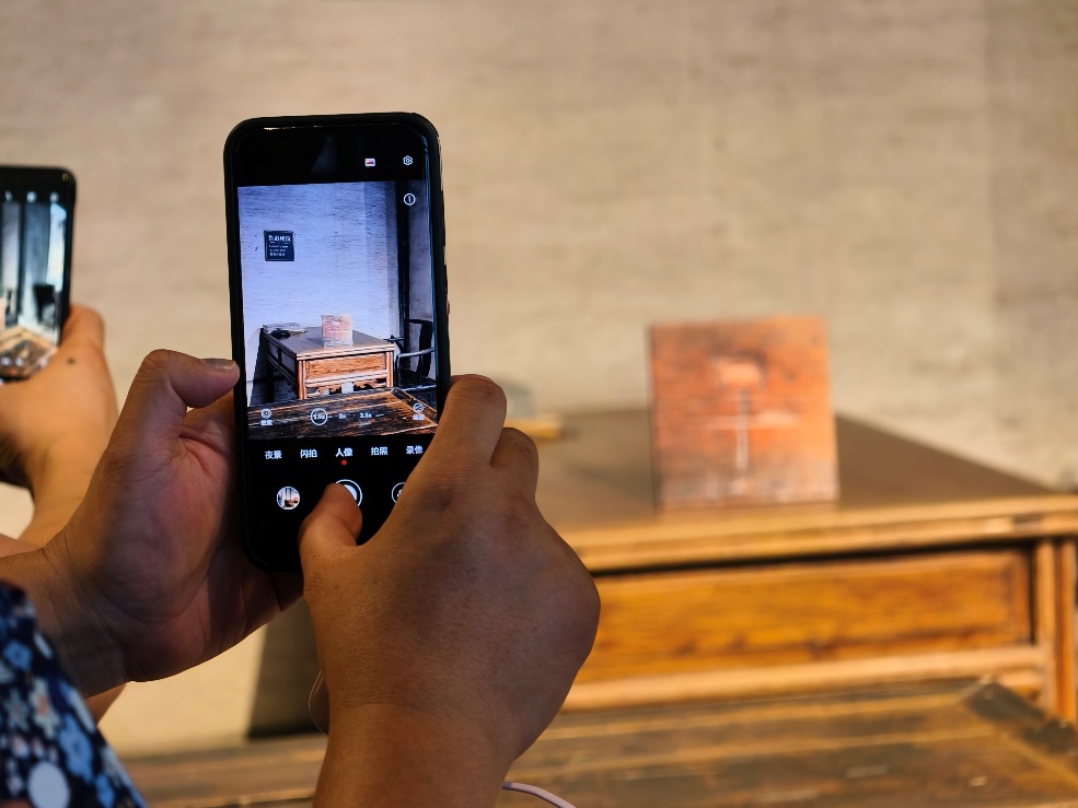 2025年7月15日，暑期研學(xué)團(tuán)小朋友在浙江省紹興市三味書屋拍攝魯迅讀書座位及課桌上的“早”字。受訪者供圖