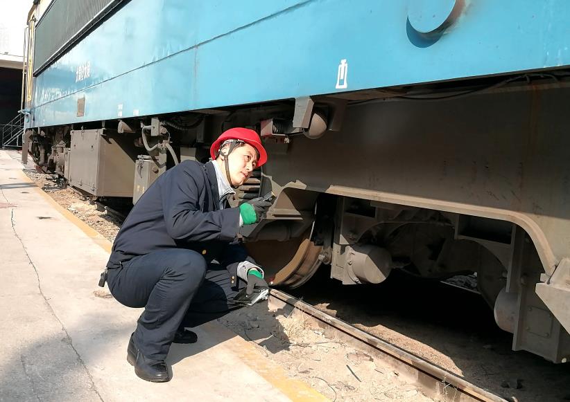 韓文盛全神貫注檢查機車走行部。