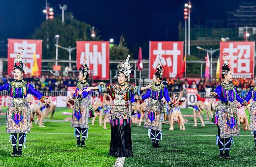 2025年3月14日，2025年貴州“村超”40強交叉賽在榕江“村超”足球場舉行，演員在比賽間隙表演侗族大歌，民族文化伴隨著體育賽事成功“出圈”。圖片來源：新華社