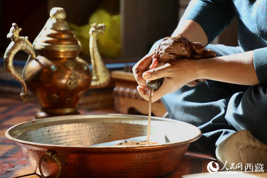 牛角鉆孔，將木泥擠出。人民網(wǎng)記者 次仁羅布攝