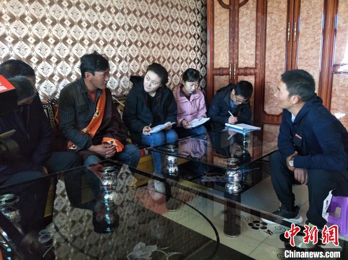 圖為調(diào)查組工作人員正在入戶調(diào)查?！∑钤鲚?攝