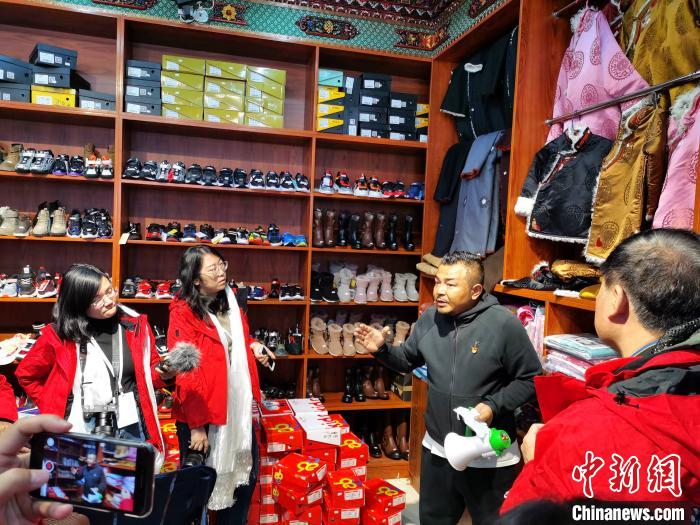 圖為中外媒體在玉樹州玉樹市甘達(dá)村采訪?！?zhí)砀?攝