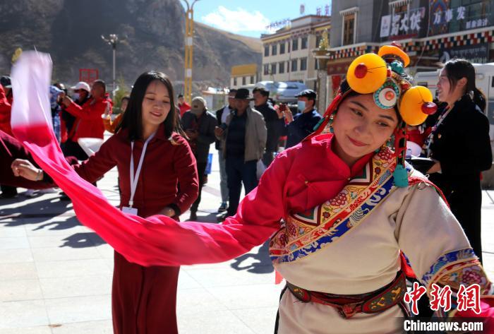 圖為中外記者向當(dāng)?shù)孛癖妼W(xué)習(xí)民族歌舞文化?！?zhí)砀?攝