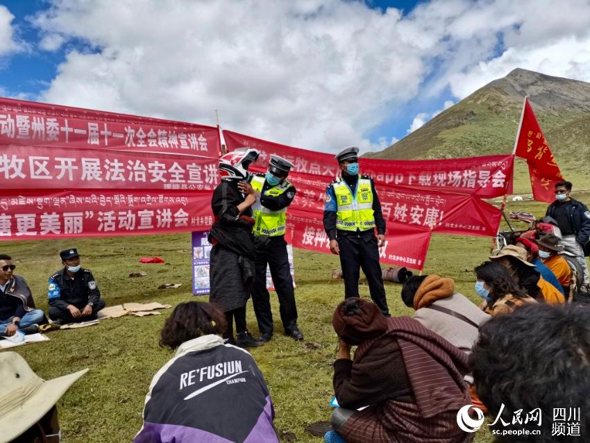 給牧民講如何佩戴安全頭盔。巴登攝