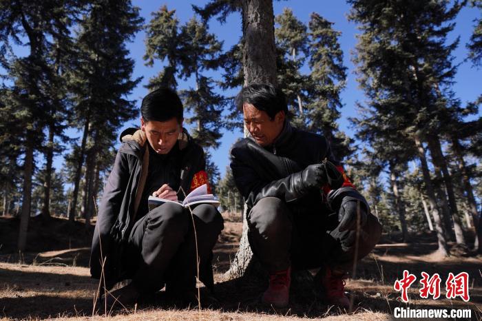 圖為桑杰加(左)和同事記錄巡查結果?！●R銘言 攝