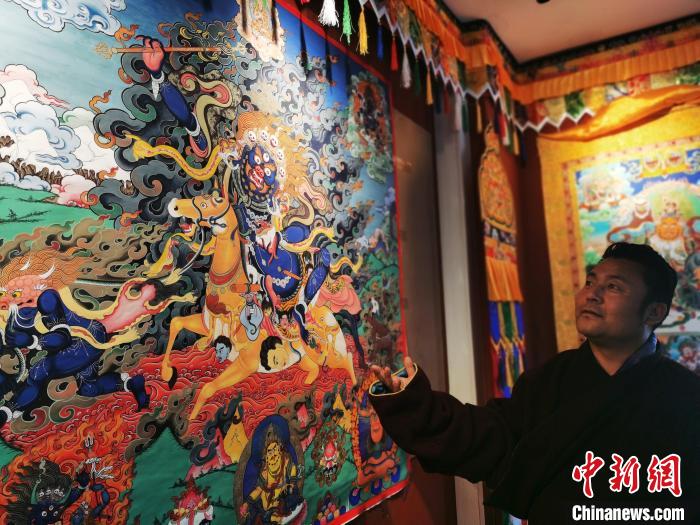圖為久美尖措展示唐卡作品。　張?zhí)砀?攝