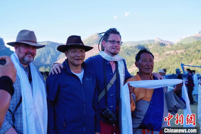 圖為當?shù)孛癖娕c外籍攝影師合影留念?！●R銘言 攝