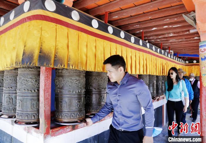 圖為外籍嘉賓體驗藏族傳統(tǒng)轉經筒?！●R銘言 攝