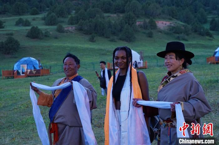 圖為當?shù)孛癖娕c外籍留學生合影留念。　馬銘言 攝