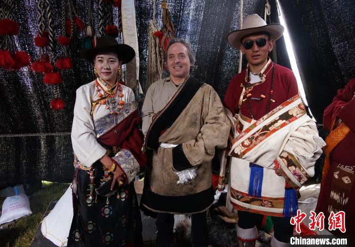 圖為一名外籍攝影師(中)身穿藏服和藏族民眾合影留念?！●R銘言 攝