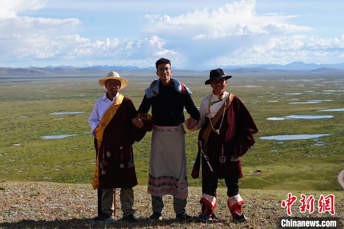 圖為一名留學生身穿自己國家的服飾和藏族民眾合影留念?！●R銘言 攝