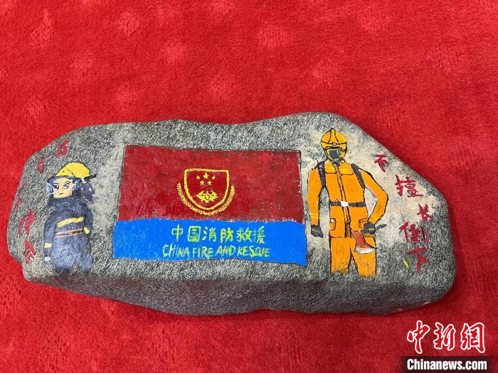 圖為玉樹消防指戰(zhàn)員創(chuàng)作的石頭畫作品《我有一個(gè)特點(diǎn)“不擅長(zhǎng)倒下”》?！O瑞祥 攝