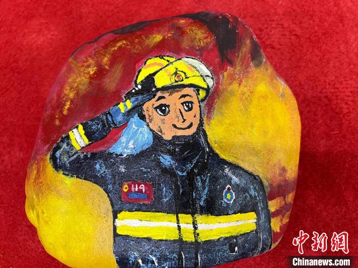 圖為玉樹消防指戰(zhàn)員創(chuàng)作的石頭畫作品《請(qǐng)祖國(guó)和人民放心》?！O瑞祥 攝