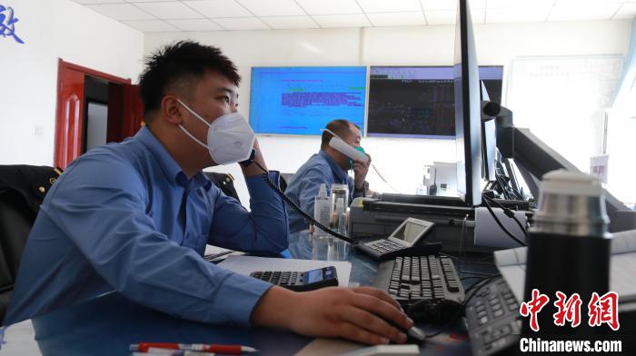 圖為貨運調度人員與外勤工作人員聯(lián)系掌握車輛裝載情況?！±钌?攝