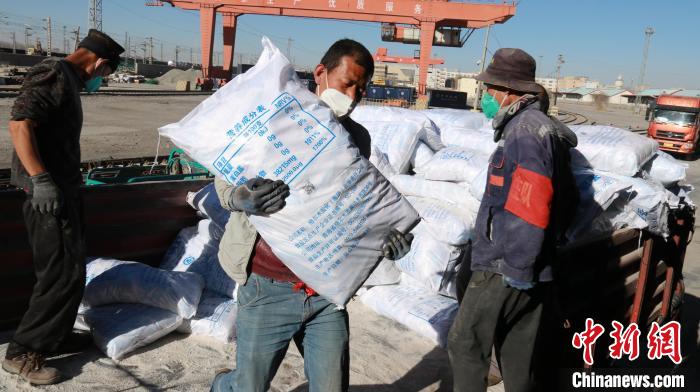 圖為裝卸人員將食鹽從汽車倒裝到火車上?！±钌?攝