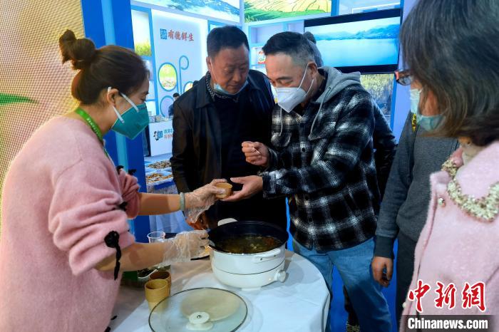 圖為杭州市民品嘗茶卡羊肉?！±铍h 攝