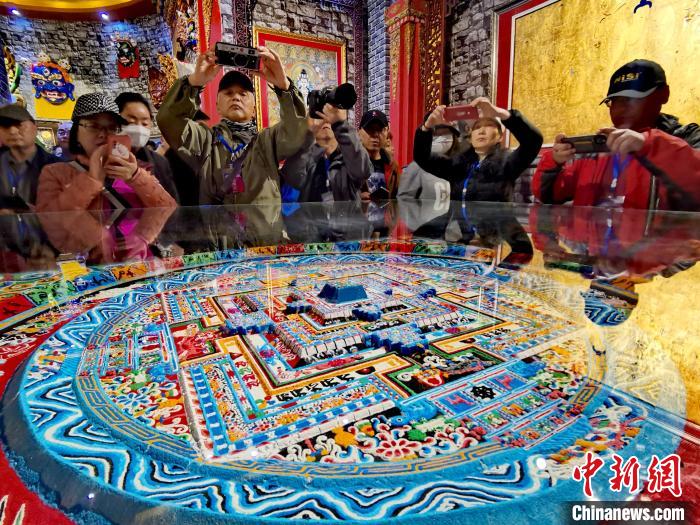 圖為參觀者拍攝壇城?！?zhí)砀?攝