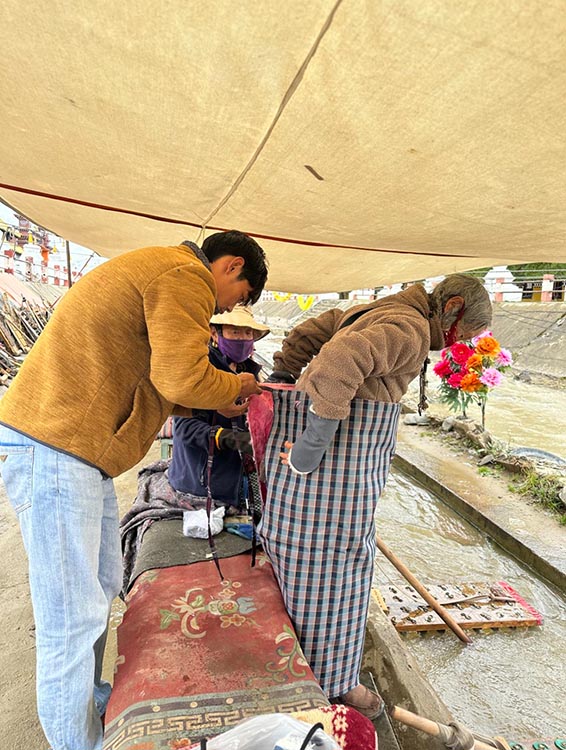 扎西奪爾登為路邊老人送去保暖圍腰。阿壩州文明辦供圖