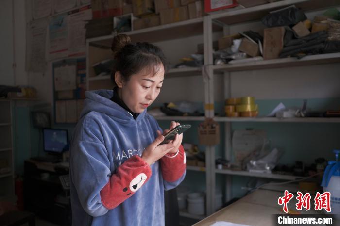 正在快遞站點(diǎn)內(nèi)忙碌的楊莉春。　何蓬磊 攝