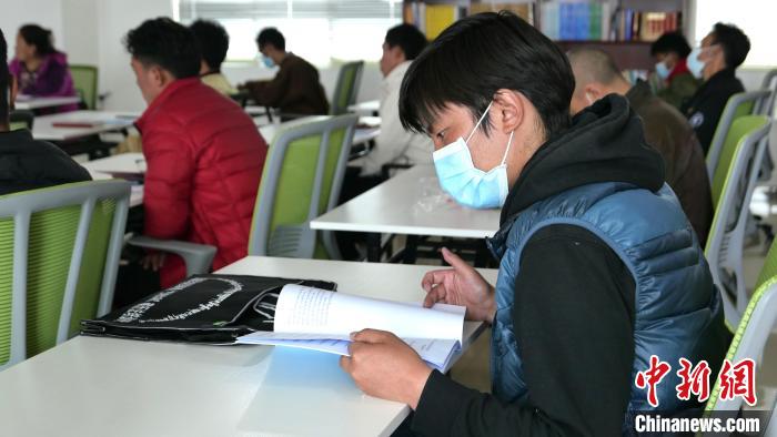 圖為正在閱讀“杰松達孜”藏歷法教材的學(xué)員。　謝牧 攝