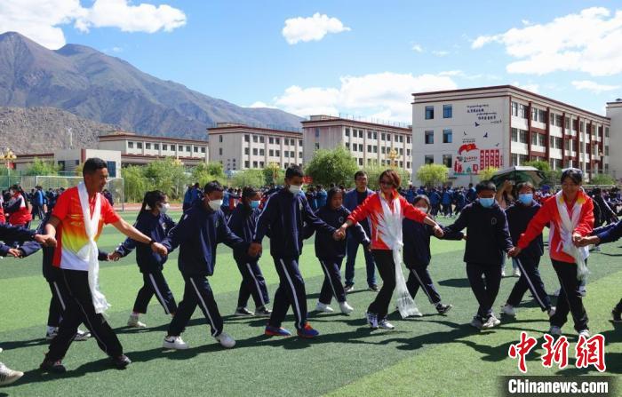 圖為世界冠軍與拉薩阿里地區(qū)高級(jí)中學(xué)學(xué)生一起跳鍋莊。　冉文娟 攝