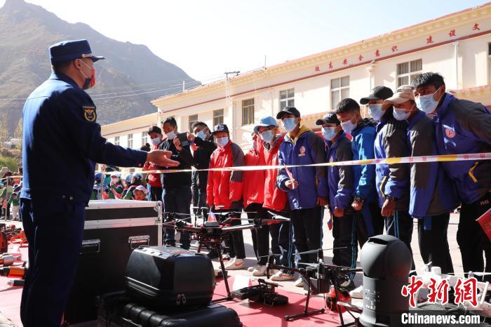 圖為消防指戰(zhàn)員為學(xué)生講解、演示先進(jìn)救援裝備?！≮w琳 攝