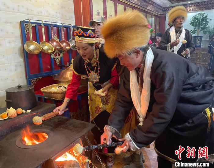 圖為人們?cè)诨鹕峡竟?jié)日美食“結(jié)達(dá)”?！∪轿木?攝