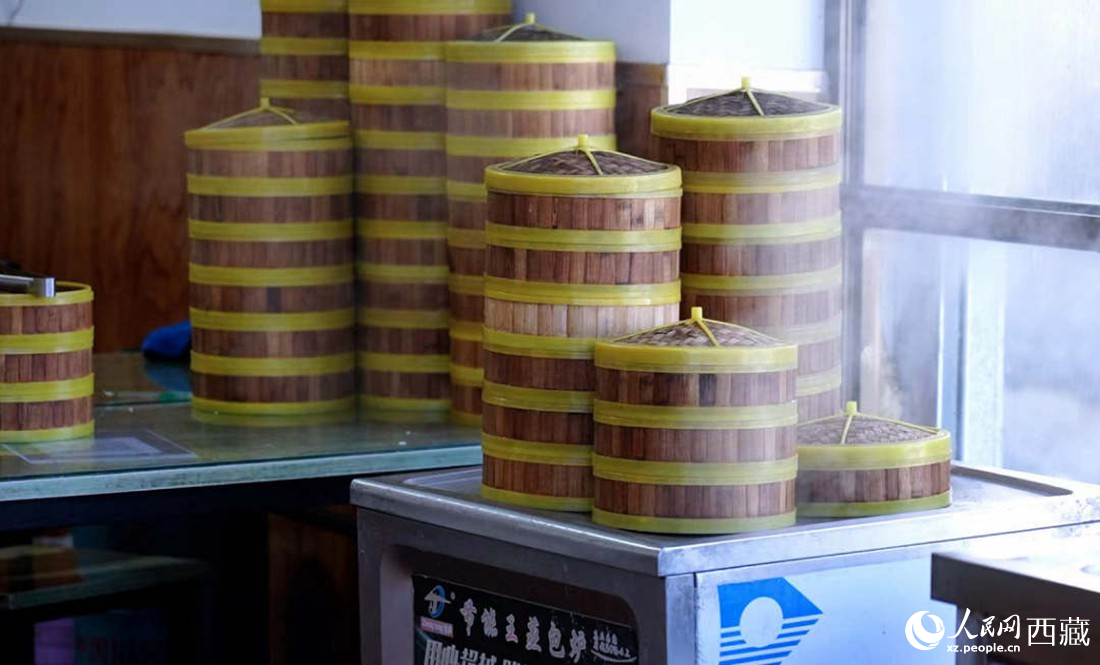 電蒸箱上擺滿了多屜熱氣騰騰的包子。人民網(wǎng) 次仁羅布攝