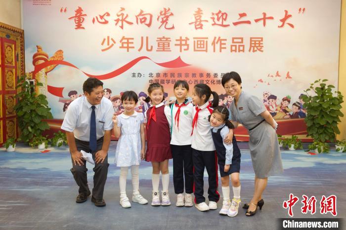 圖為與會(huì)嘉賓與入選畫(huà)作的“小作者”們?cè)谡褂[上合影?！≈袊?guó)藏學(xué)研究中心供圖