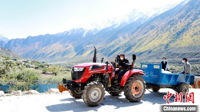 圖為工作人員將把加工完成的糌粑運送至村民手中?！〖卫杩h融媒體中心供圖