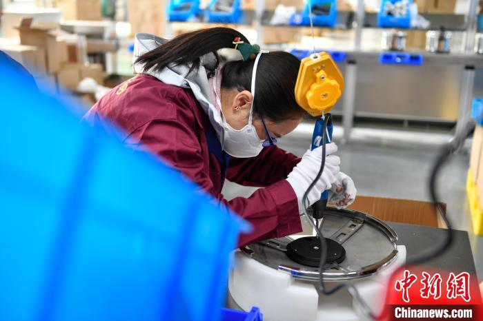 圖為工人正在組裝炊具。　貢嘎來松 攝