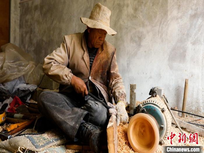 圖為手工藝人正在制作木碗?！?鄧海平 攝