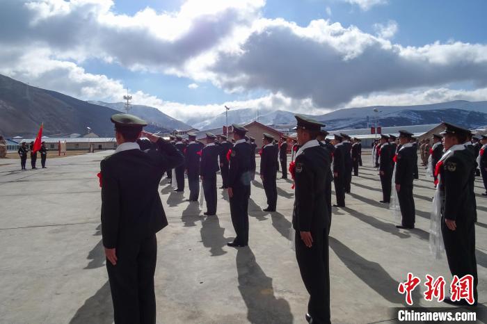 雪山下，退役士兵向軍旗敬軍禮。　李學文 攝
