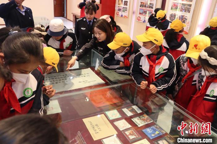 圖為亞?wèn)|邊檢站民警為駐地小學(xué)生講解該站榮譽(yù)發(fā)展史?！『?攝