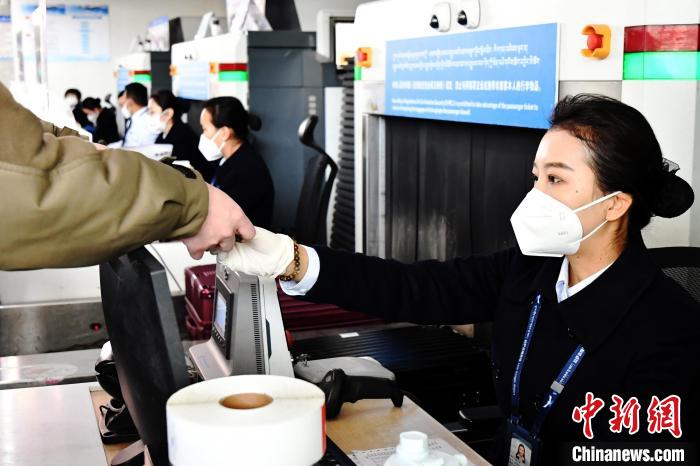 圖為機(jī)場(chǎng)工作人員為旅客辦理行李托運(yùn)。　周航 攝