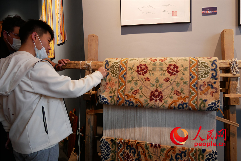 觀眾正在觀賞展出的藏毯。人民網(wǎng) 韋衍行攝
