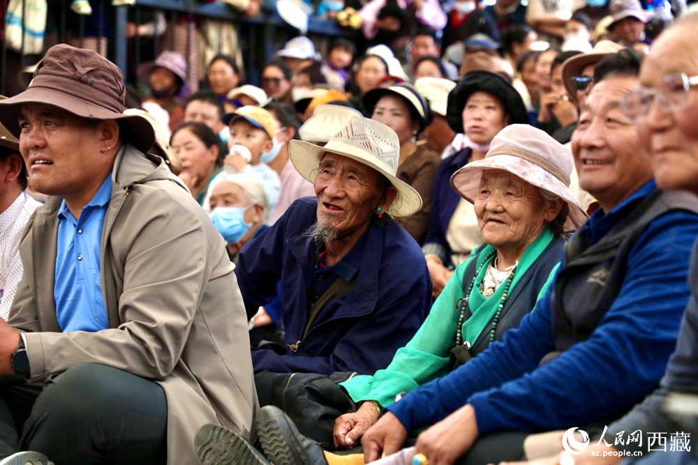 當(dāng)?shù)厝罕姾陀慰陀^看藏戲演出。