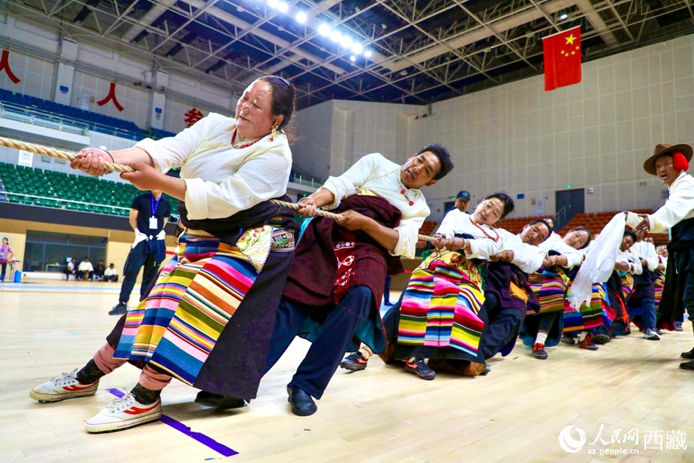 身著民族服裝的農(nóng)牧民選手在拔河比賽現(xiàn)場(chǎng)。