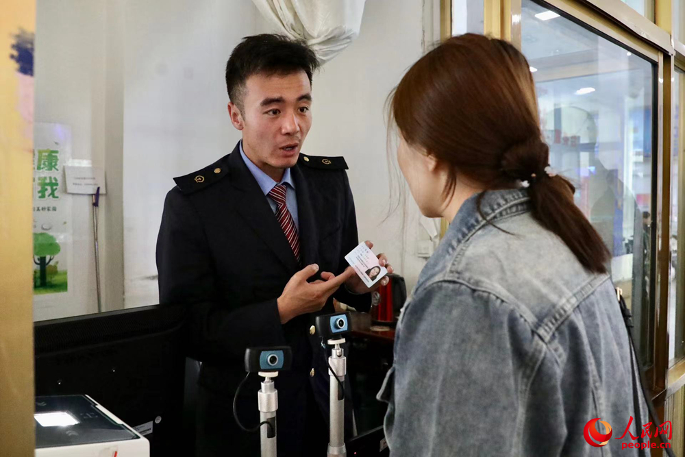 車站工作人員向旅客解答疑問(wèn)。人民網(wǎng)記者 次仁羅布攝