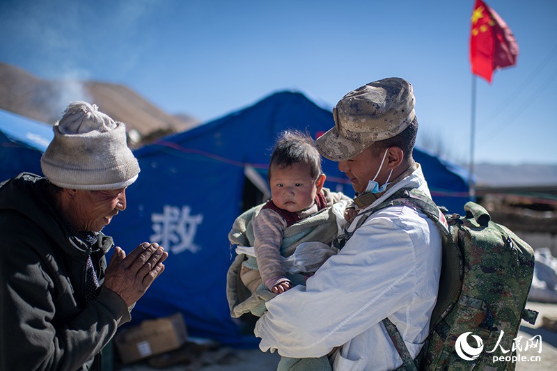 1月9日，在定日縣長所鄉(xiāng)古榮村安置點，受災群眾感謝西藏軍區(qū)陸軍某部隊衛(wèi)生員的醫(yī)療救治。人民網(wǎng)記者 翁奇羽攝