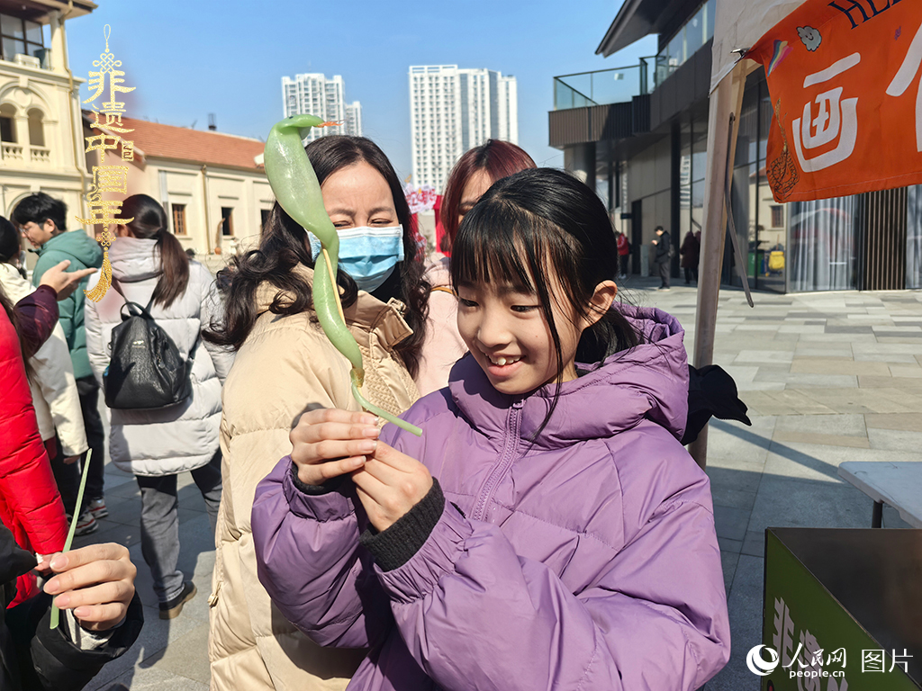2025年1月29日，湖北武漢的新春廟會上，小朋友拿著吹制好的糖人，十分開心。人民網(wǎng)記者 張沛攝