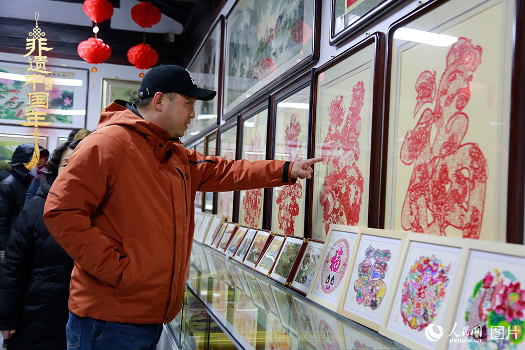 2025年1月23日，游客在天津楊柳青古鎮(zhèn)欣賞傳統(tǒng)剪紙作品，感受指尖上的古老藝術(shù)。人民網(wǎng)記者 崔新耀攝